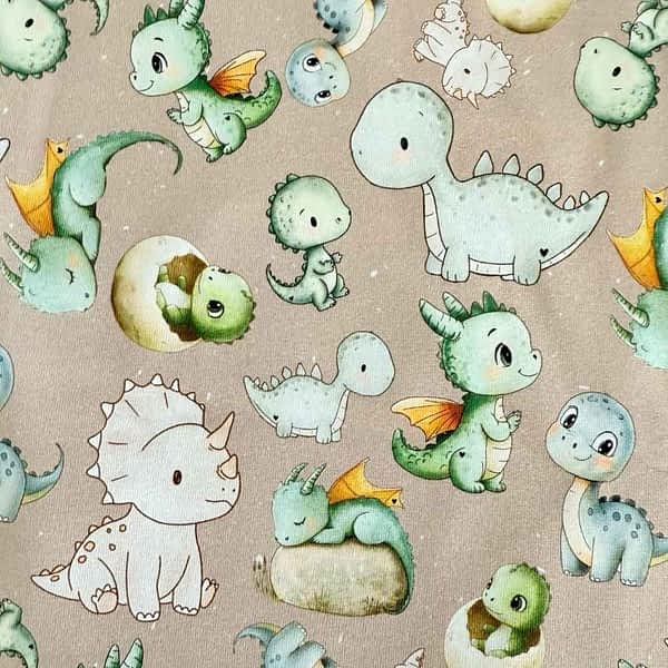 Jersey-Stoff mit niedlichen Dinos & Drachen in Pastellfarben auf einem beigefarbenen Hintergrund - perfekt für verspielte handgemachte Babykleidung & Kindermode und Mitwachskleidung