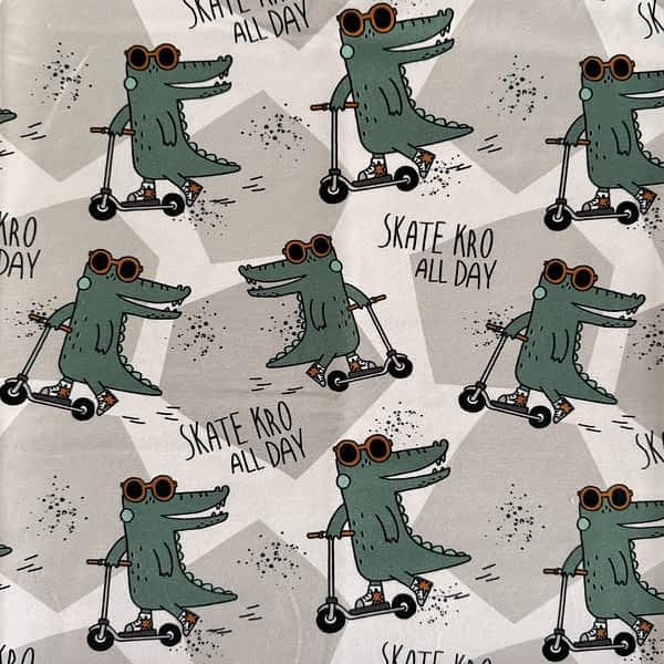 Hellgrauer Jersey-Stoff mit Skater-Krokodilen auf Rollern und dem Schriftzug ‚Skate Kro All Day‘ – perfekt für stylische Kinderkleidung